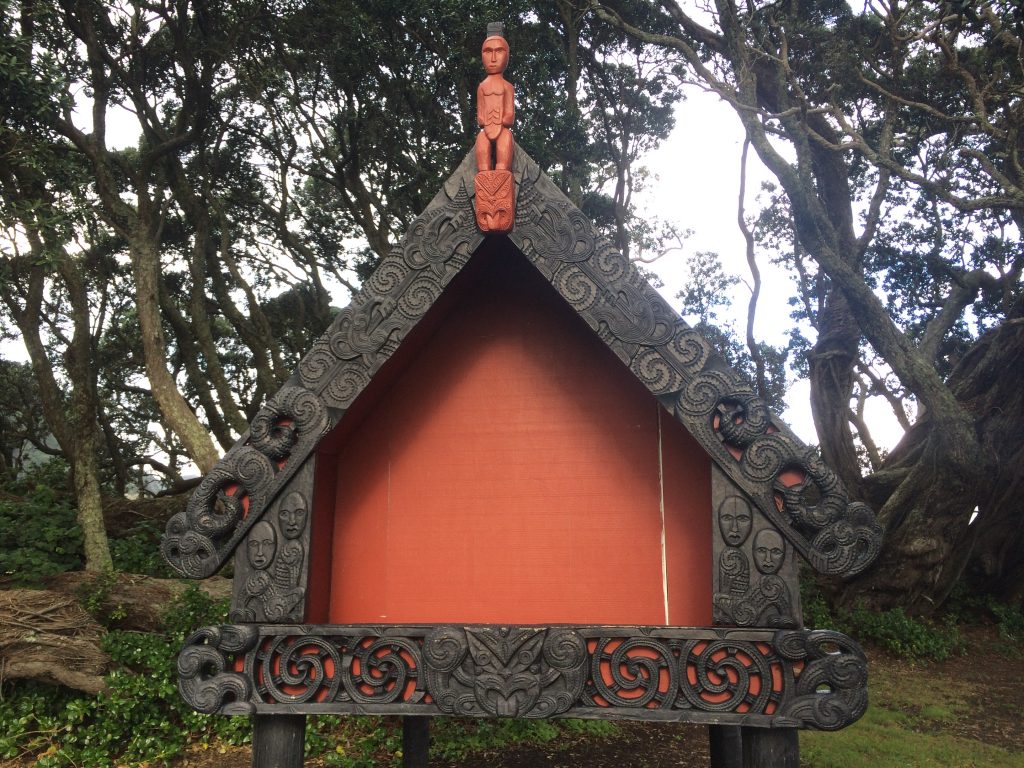 Maori woodcarving next to Te Waha O Rerekohu Pohutukawa