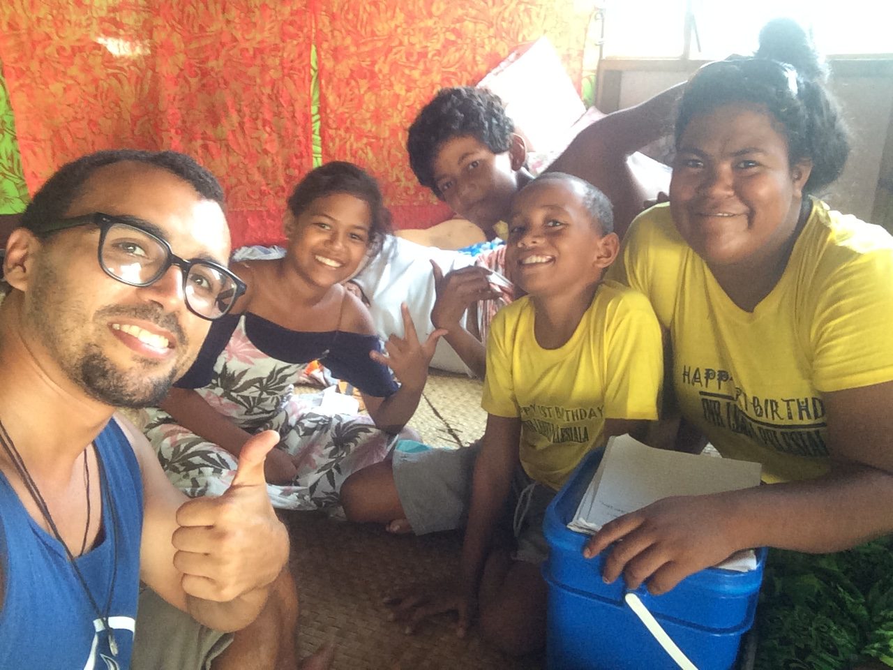 A heartwarming photo capturing the inclusivity and warmth of Tuvalu's community. In the picture, the user stands among friendly locals, their smiles reflecting genuine hospitality. The backdrop showcases Tuvalu's scenic beauty, emphasizing the spirit of cultural exchange and connection between the user and the people of Tuvalu.