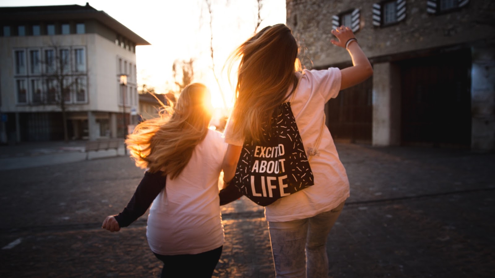 girls happy jumping sunset