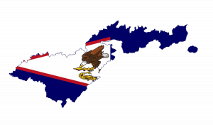 Outline map of American Samoa with the American Samoan flag in the background. The flag features a bald eagle, a symbol of the United States, and local cultural elements representing the islands' heritage. The map outlines the unique shape of the American Samoa archipelago, located in the South Pacific Ocean