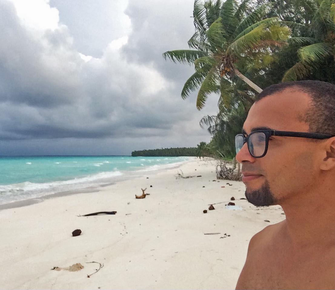 Alt Image Description: "A serene scene captured from the Marshall Islands' outer islands. The image depicts the user gazing out at the vast, peaceful beachscape. The soft golden sands meet the crystal-clear turquoise waters, creating a tranquil contrast against the vibrant blue sky. The moment embodies a sense of awe and appreciation for the untouched natural beauty of the Marshall Islands' outer islands, showcasing the harmony between the user and the picturesque surroundings.
