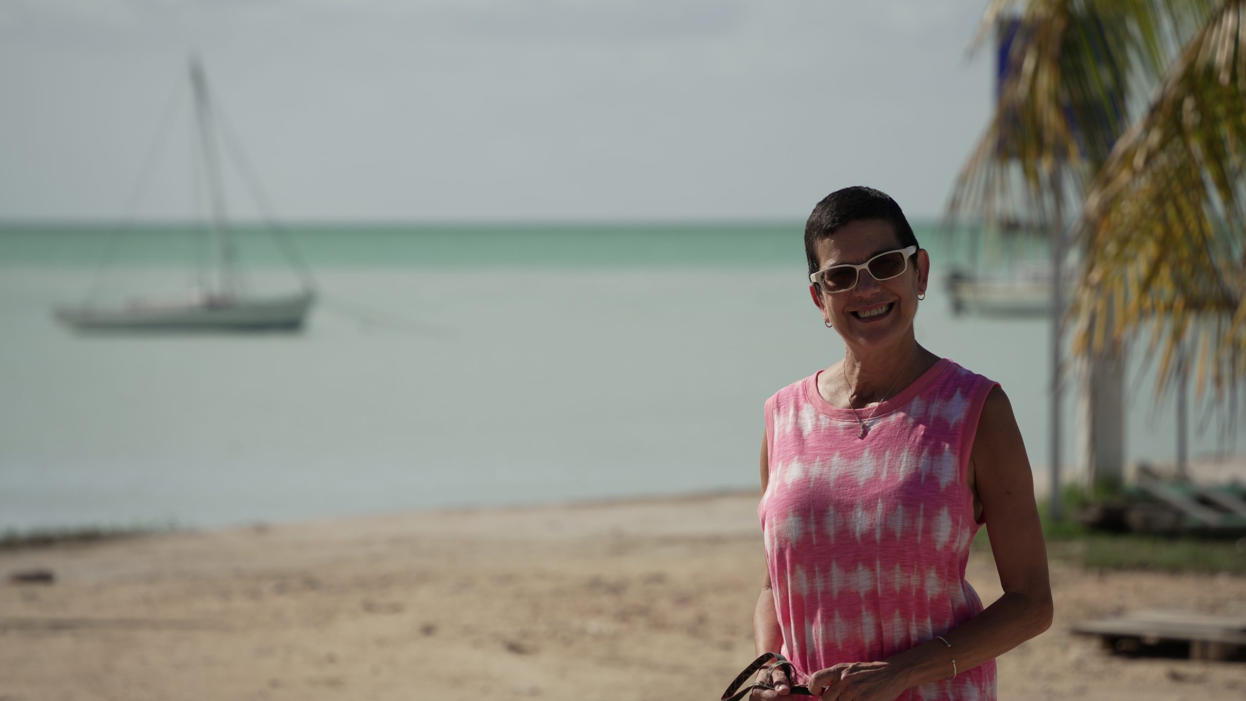 photo of woman with sailboat in background belize