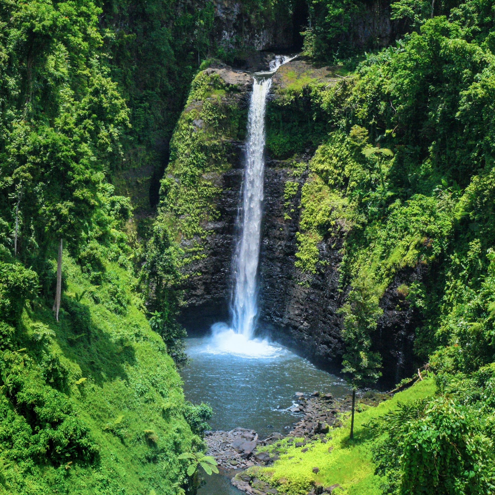 waterfalls in samoa surrounded my lush green mountain landscape